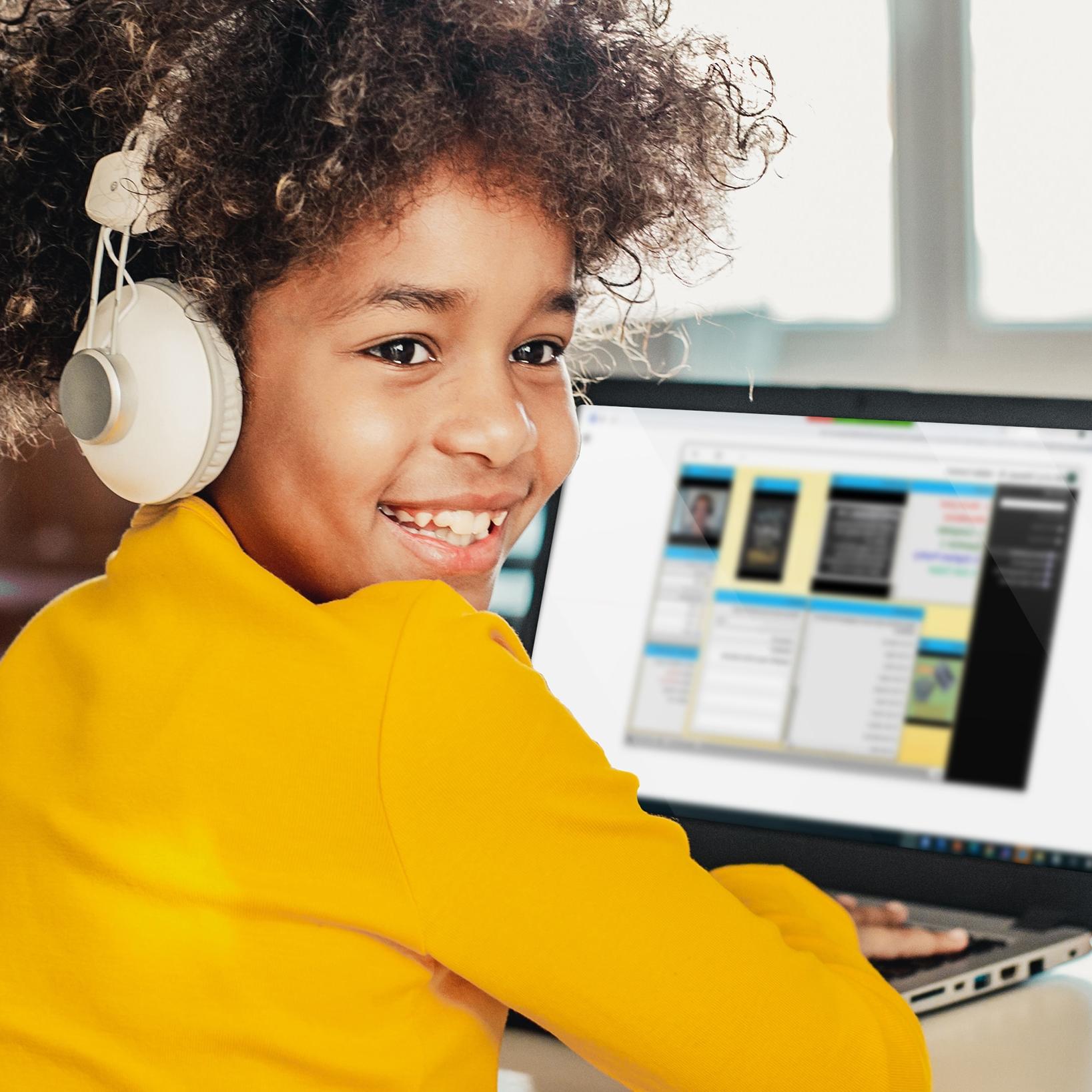 A young girl is smiling while listening to an online lesson