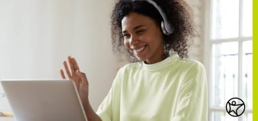 A women is waving at laptop for an online class